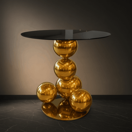 Table basse avec base en sphères dorées et plateau rond en verre fumé.
