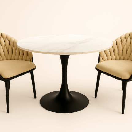 Deux fauteuils tressés beige autour d’une table ronde à plateau marbre blanc.