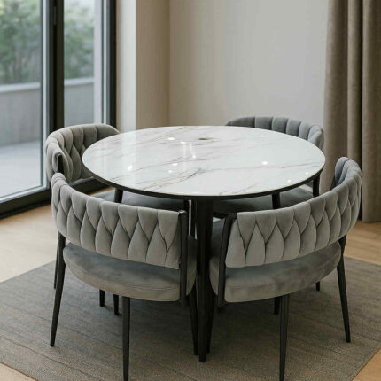 Quatre fauteuils noirs tressés autour d’une table carrée à plateau effet marbre.