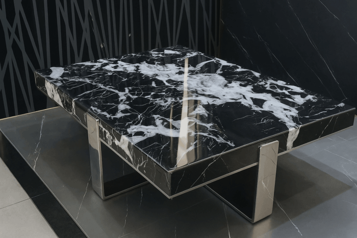 Table basse avec plateau rock slab texturé brillant et piètement en métal noir mat. Table basse avec plateau rock slab texturé brillant et piètement en métal noir mat.