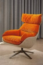 Fauteuil enveloppant pivotant en tissu moelleux couleur terracotta.